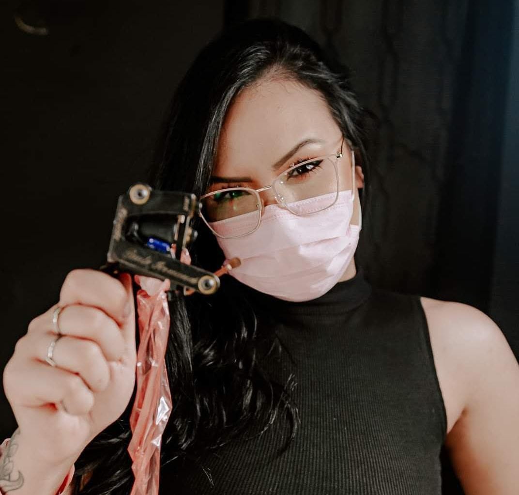 Aline Druco segurando a máquina de tatuar no estúdio