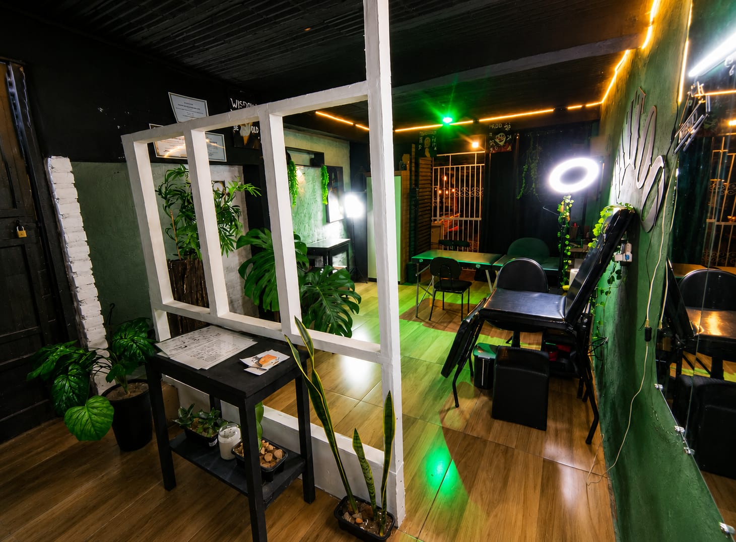 Interior do estúdio Druco Tattoo com parede verde e macas